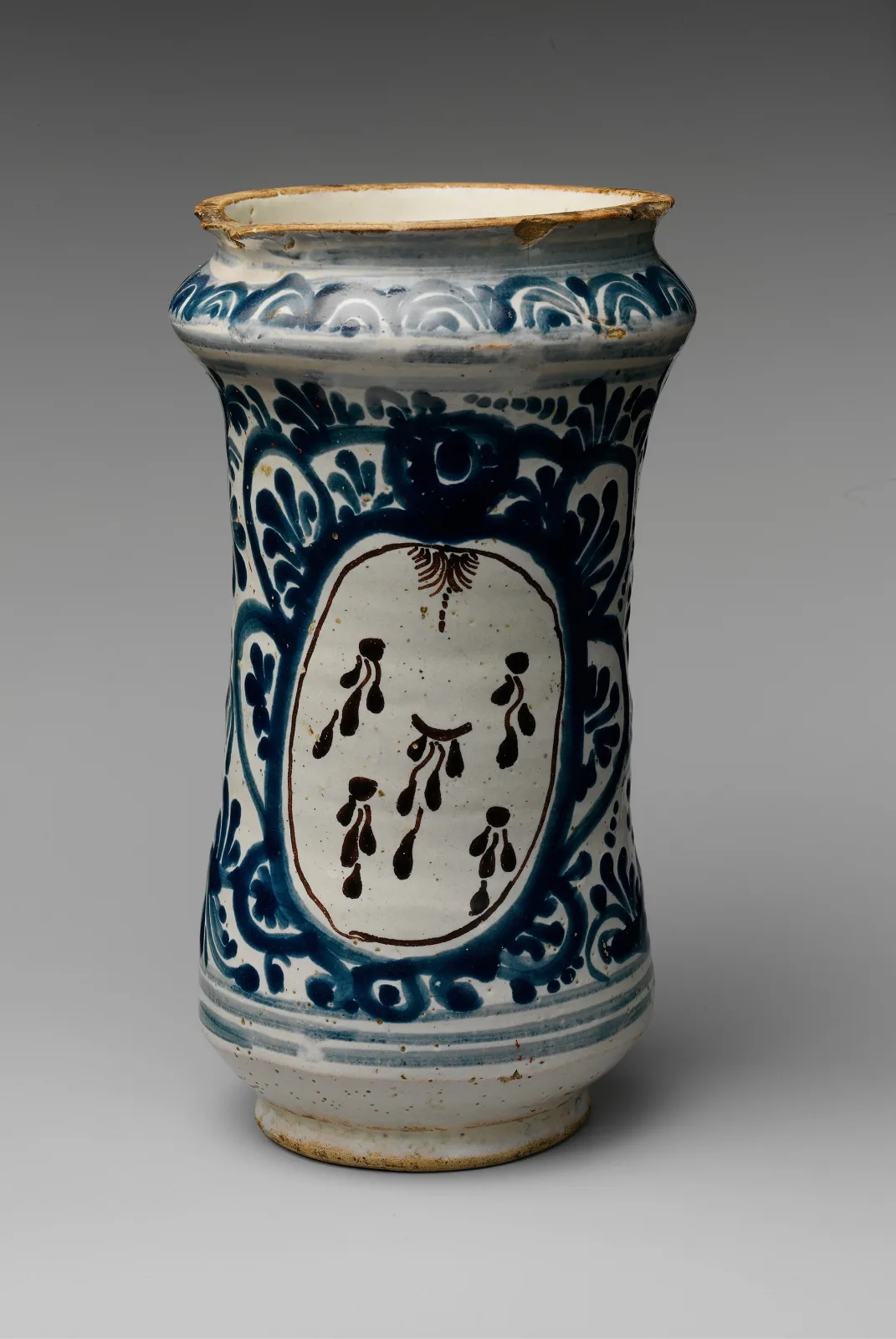 Mexican tin-glazed apothecary jar painted in blue on white, waisted albarello form, with a framed oval reserve in the centre of the body left empty of lettering