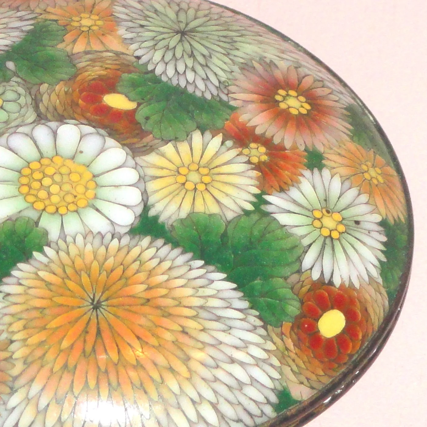 Domed lid densely covered with chrysanthemum blooms in white, orange and yellow on a pale ground, each petal separated by a fine metal wire