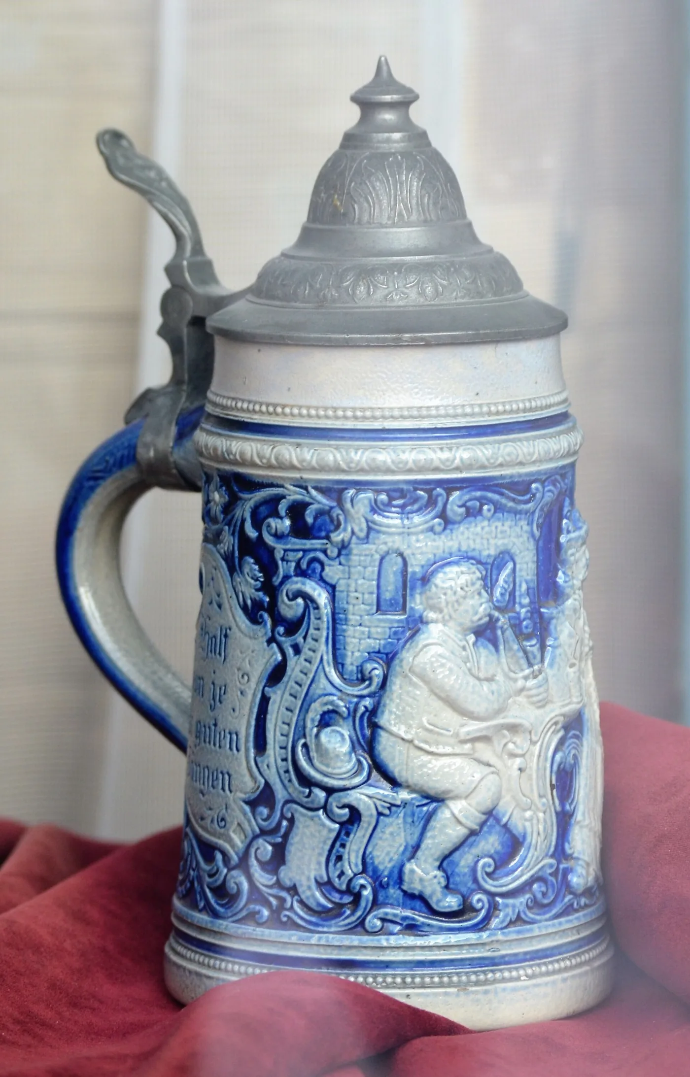 Blue and grey salt-glazed stoneware stein with a relief figure and a hinged pewter lid