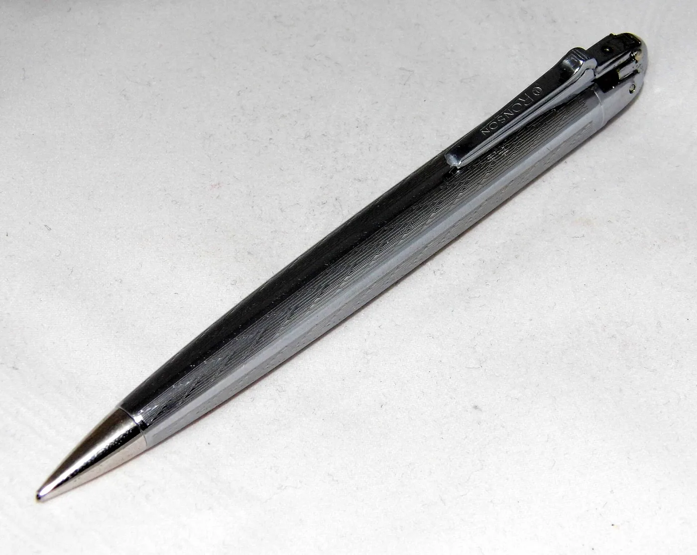 Chrome propelling pencil with a fine engine-turned wavy pattern, a pencil point at one end and a small lighter mechanism built into the other, with RONSON stamped on the pocket clip