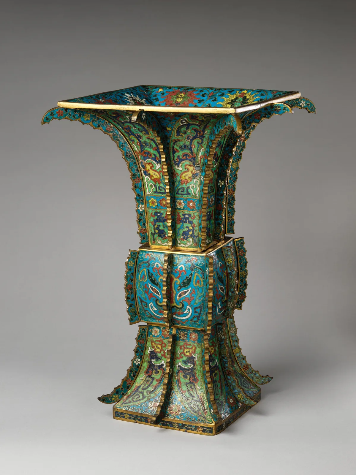 A tall square-sectioned cloisonne vase with a flaring mouth and vertical flanges, in the form of an archaic bronze wine vessel