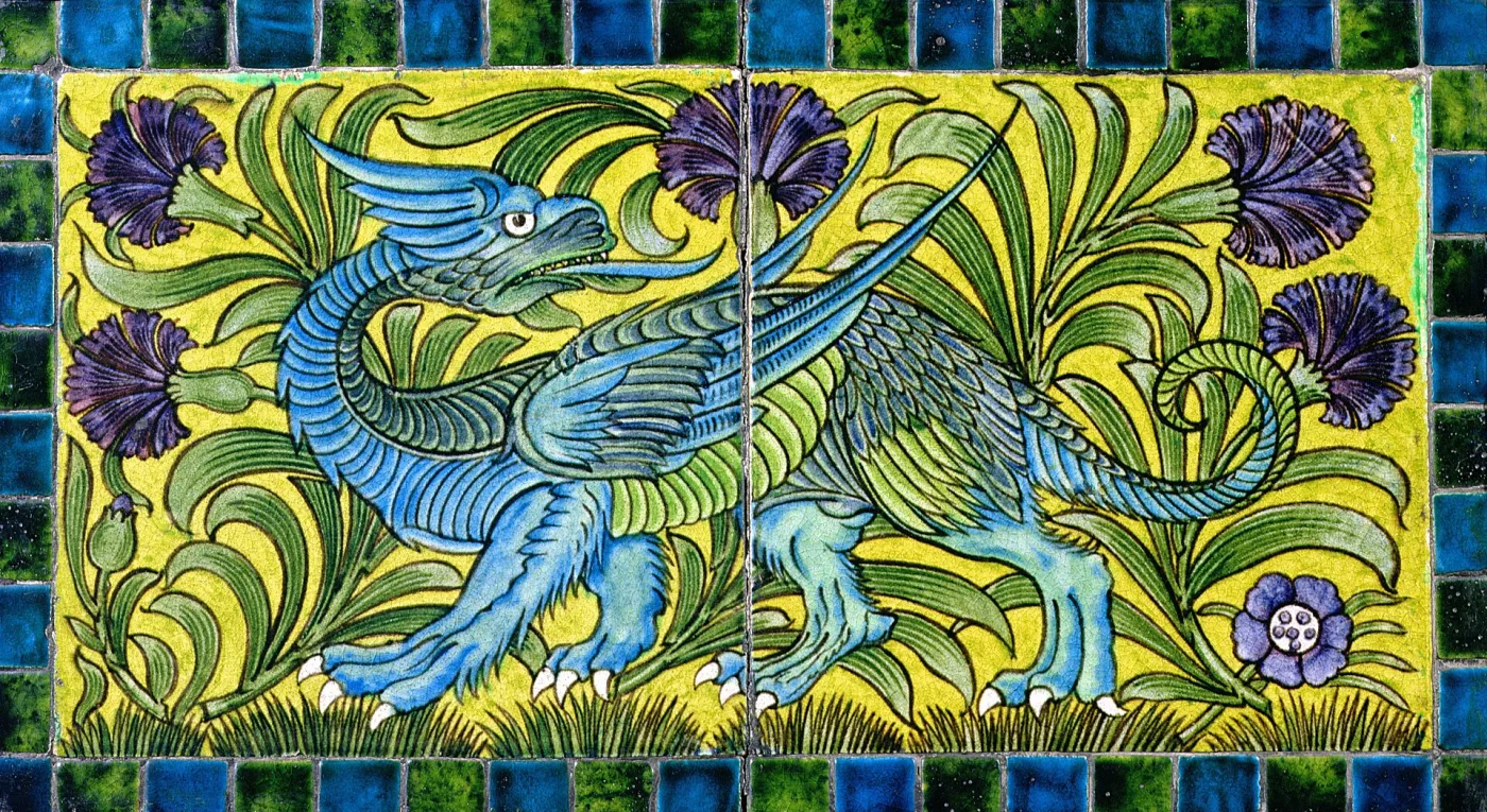 Panel of two tiles painted with a winged blue-and-turquoise dragon striding through green foliage and purple flowers on a yellow ground, framed by a border of small blue and green square tiles