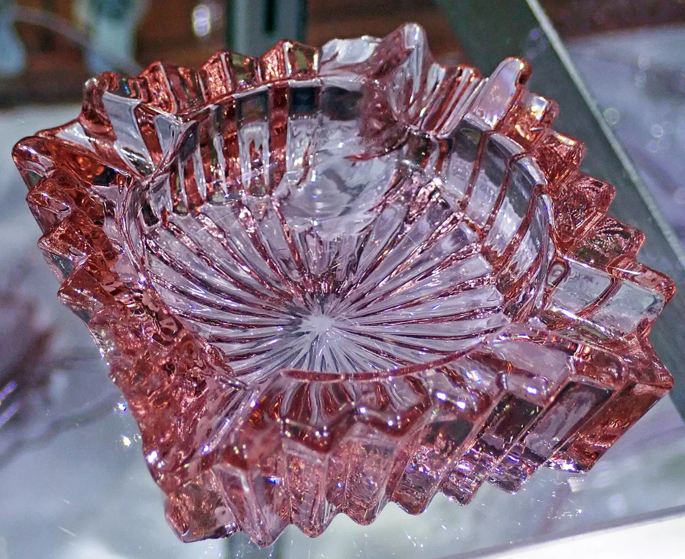 Lavender pressed glass ashtray with a fluted, sharply ridged rim, seen from above