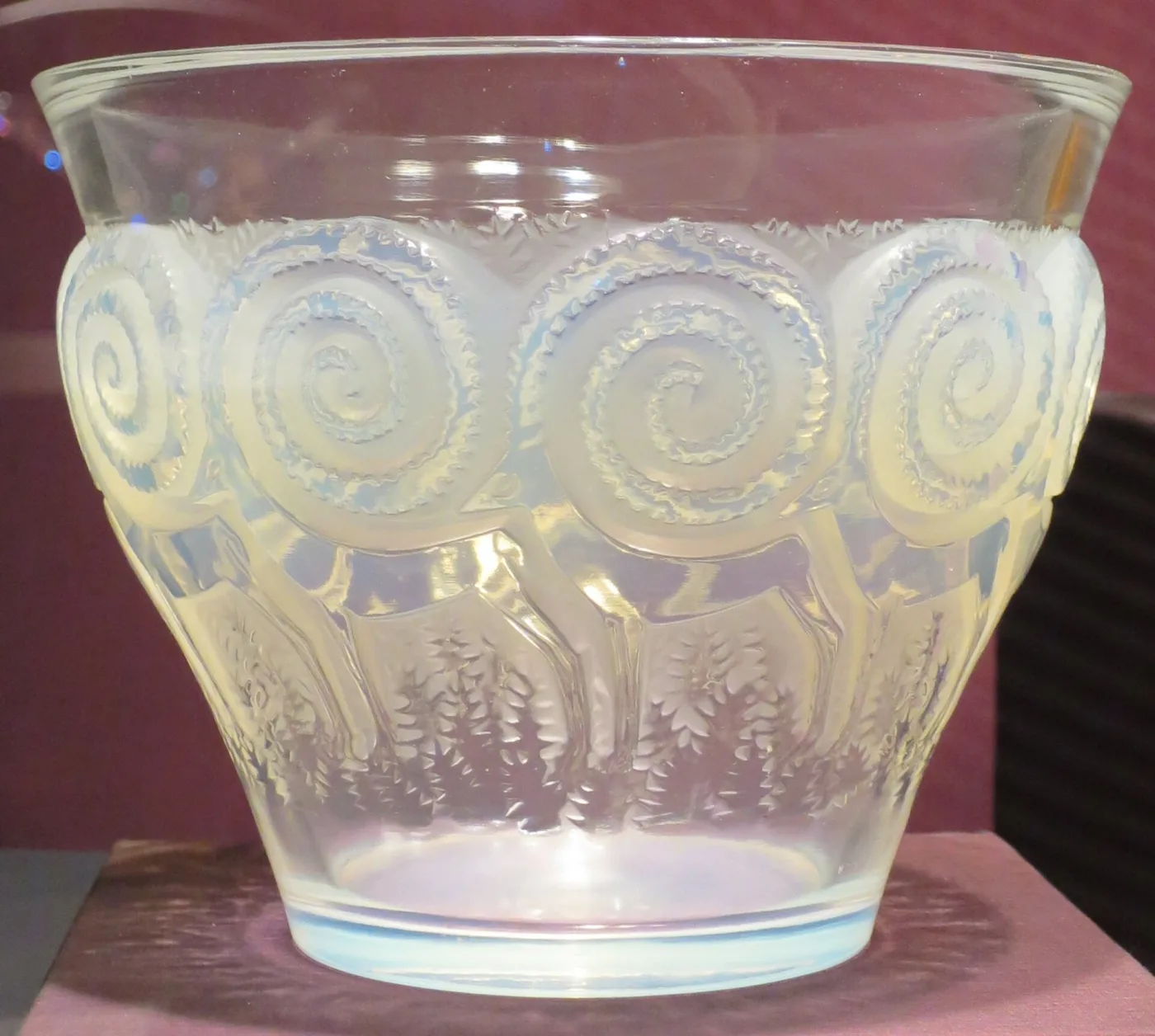 Deep opalescent bowl-shaped vase moulded with a band of large spirals above a row of running deer, the glass shading from milky white to pale blue