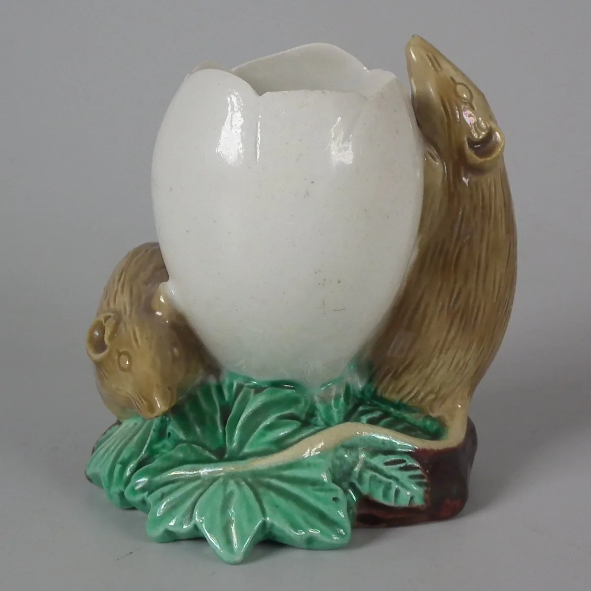 Small posy holder modelled as two mice climbing on a large white egg, mounted on a leaf-shaped base