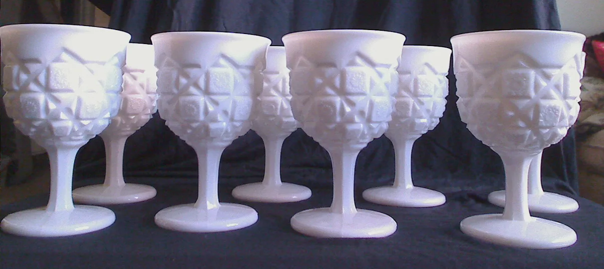 Seven white milk glass goblets pressed with a quilted pattern of raised squares and crosshatched blocks