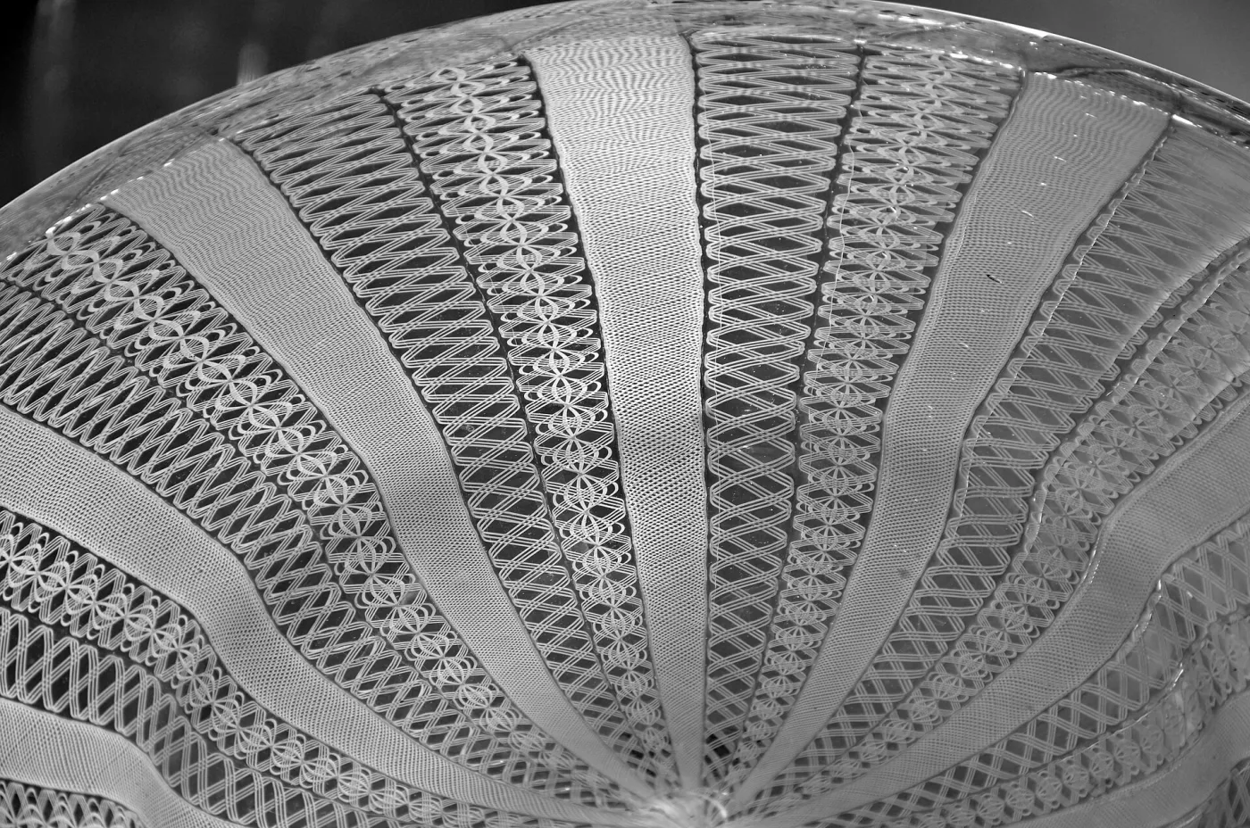 Close view of a filigrana bowl showing white glass threads radiating in an even lattice