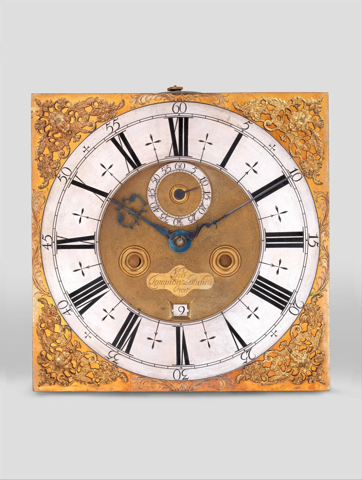 Square brass clock dial with a silvered Roman chapter ring, cast winged-cherub corner spandrels, an engraved signature cartouche and a small square date aperture below it
