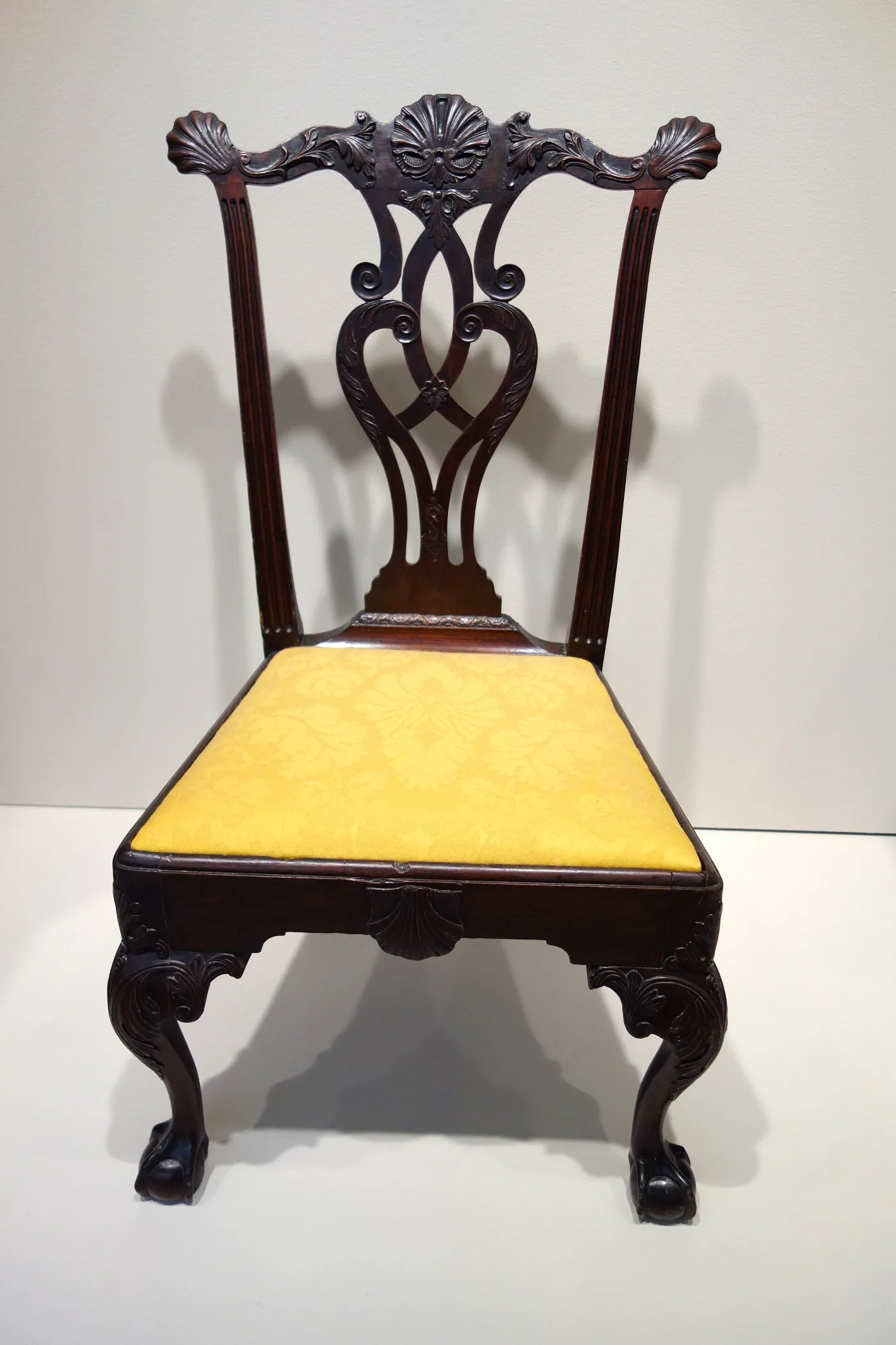 Mahogany side chair with a shell-carved crest rail, pierced and carved interlaced splat, carved knees and ball-and-claw feet