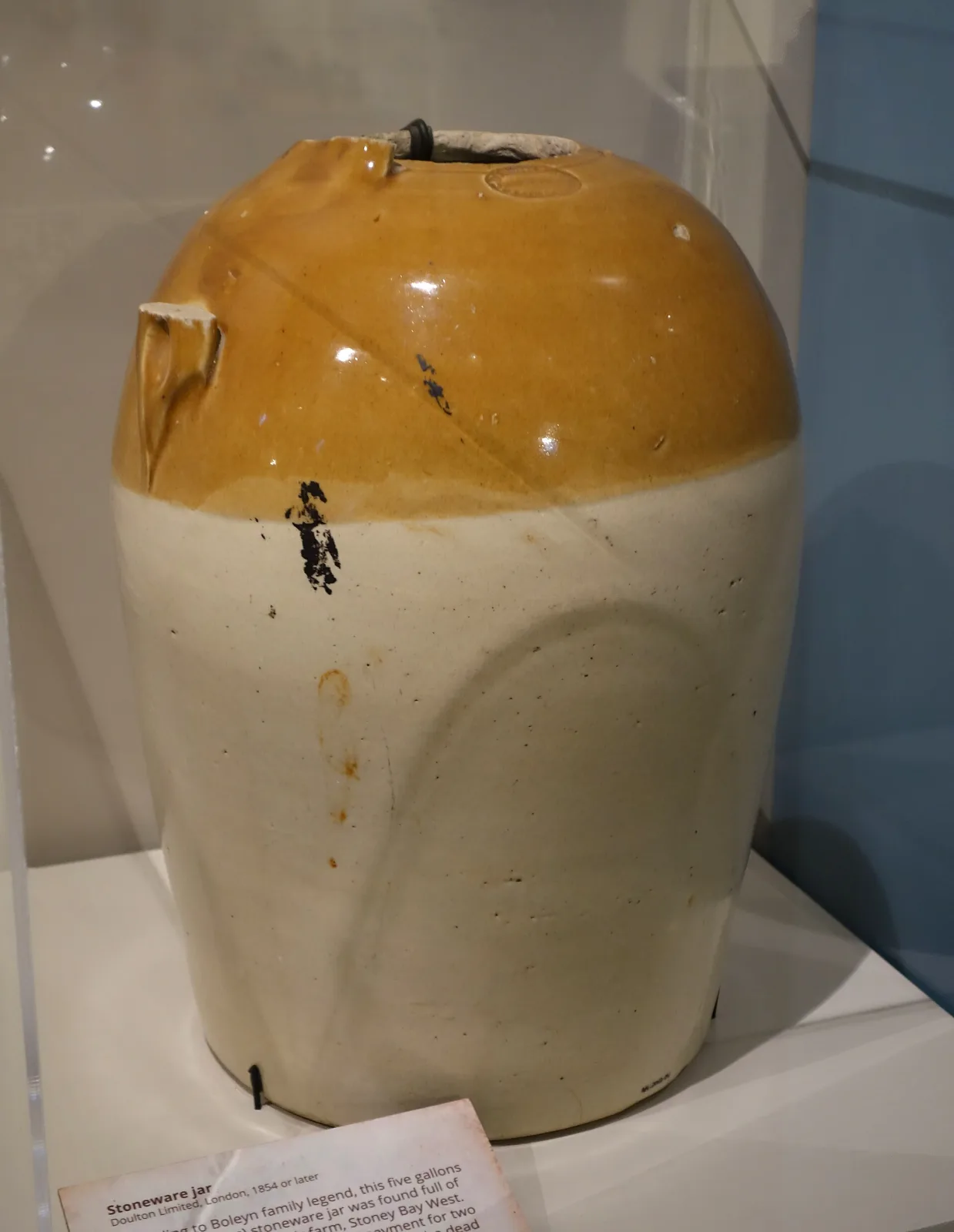 Large plain salt-glazed stoneware jar with a swelling body, a short neck and two small lug handles, its surface a mottled ochre and grey with a slight orange-peel texture