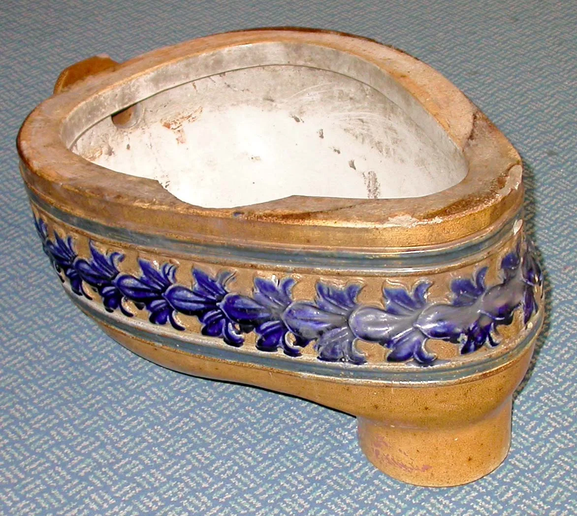 Victorian stoneware lavatory pan seen from above, its interior white-glazed and its buff outer wall banded with a printed frieze of blue and purple flowers