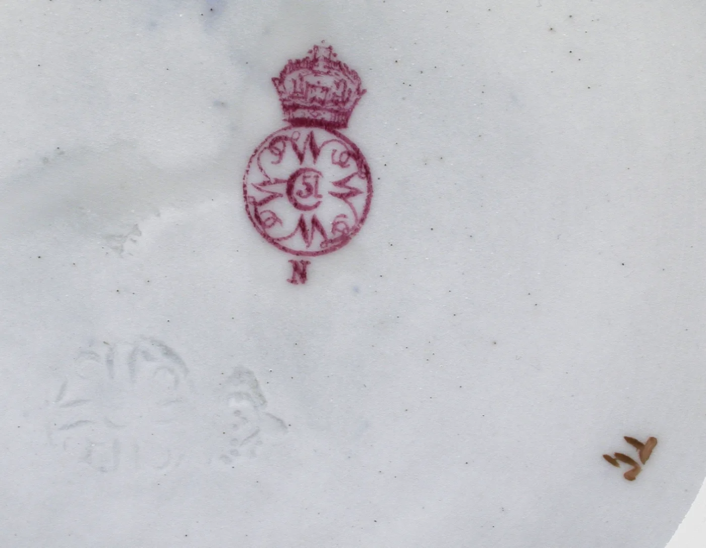 Puce printed mark on white porcelain showing a crown above a circle containing the number 51, a single letter beneath the circle, and two faint impressed devices alongside