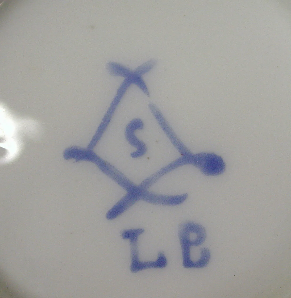 Underglaze blue interlaced-L cipher with the letter S inside it and the initials LB painted below