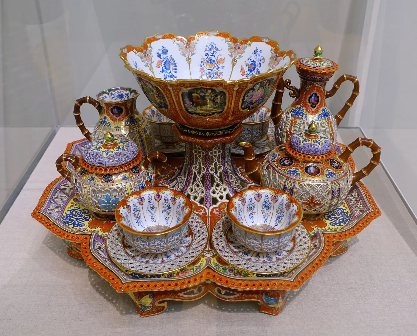 Elaborate nineteenth-century Sèvres tea and coffee service with pierced orange, blue and purple chinoiserie decoration, arranged on a shaped tray