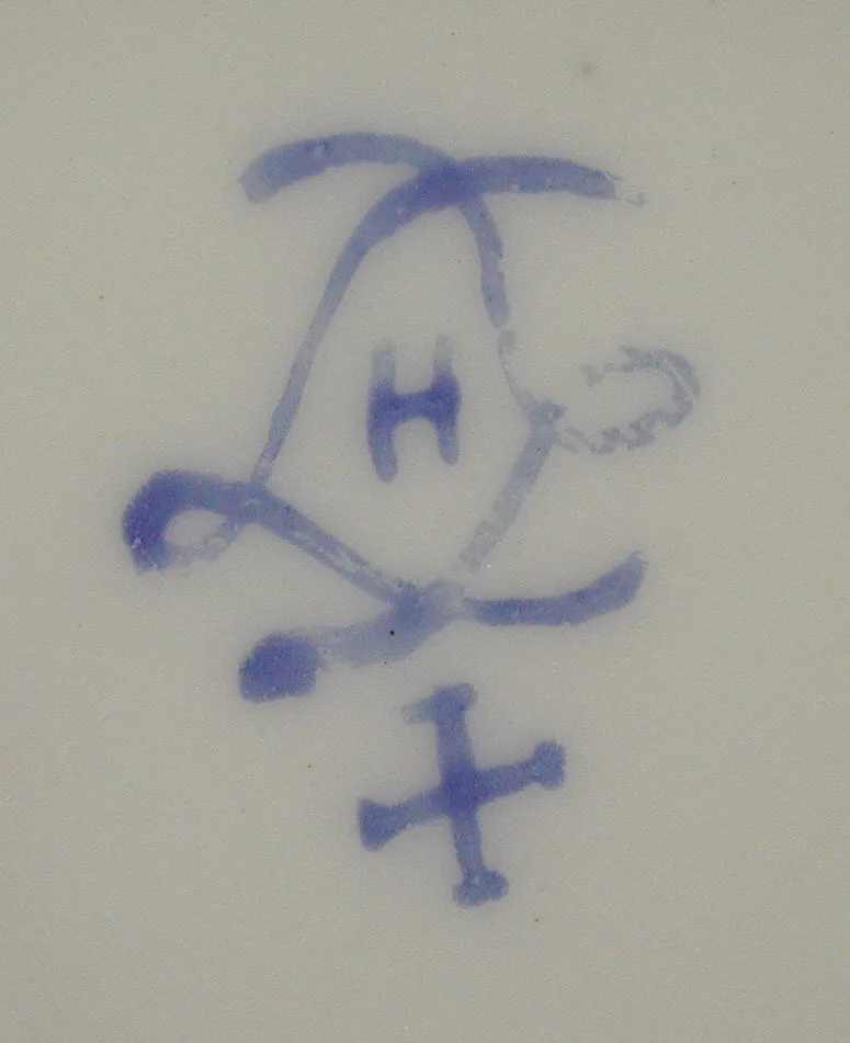Underglaze blue interlaced-L cipher enclosing the letter H, with a cross-shaped mark painted below it