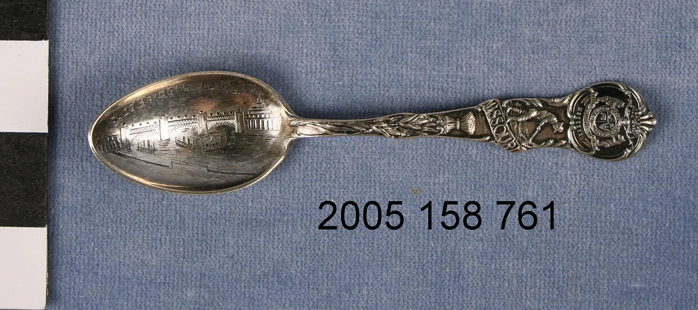 Silver souvenir spoon with the Eads Bridge worked into the bowl and MISSOURI, an animal and a state seal running up the handle