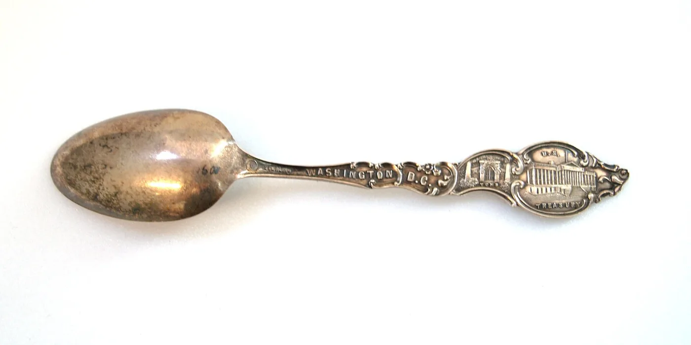 Souvenir spoon photographed from the back, the stem struck with the word STERLING beside WASHINGTON D.C.