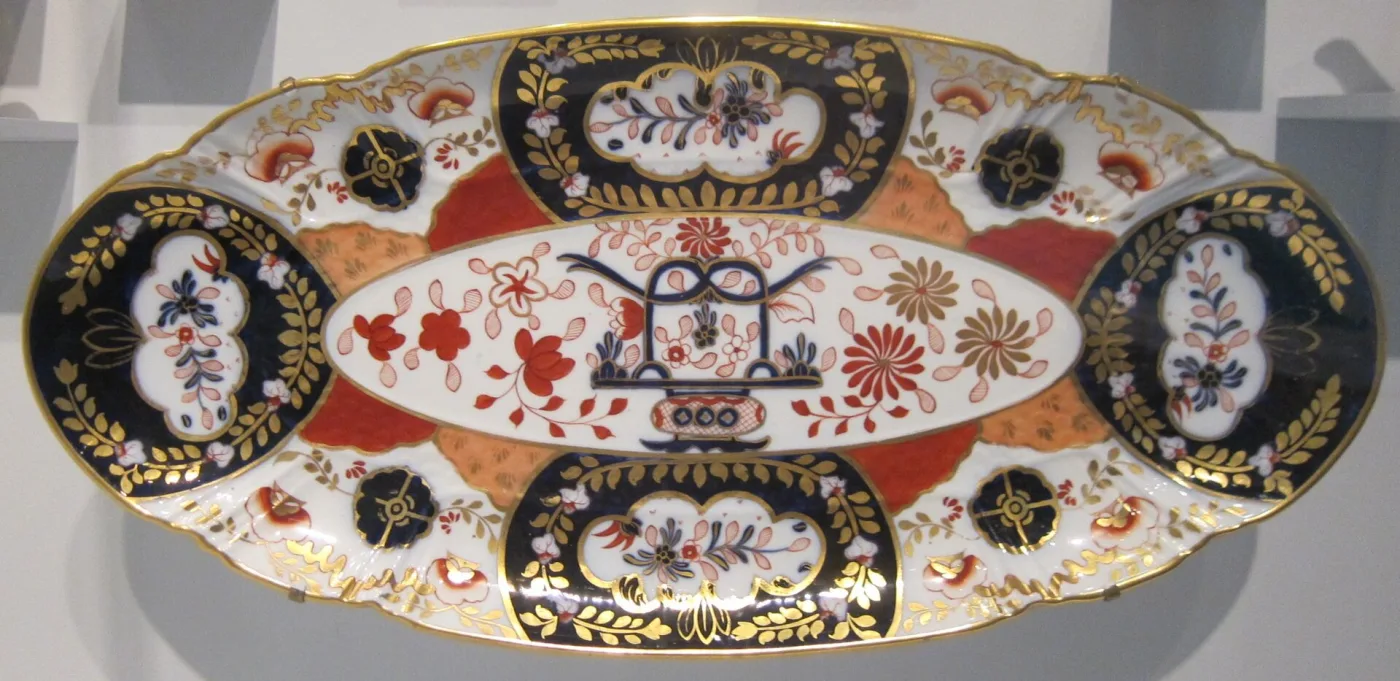 Long oval fish platter of 1883 decorated in the Imari palette, with cobalt and gilt panels alternating round the rim and an orange and red flower spray in the centre well
