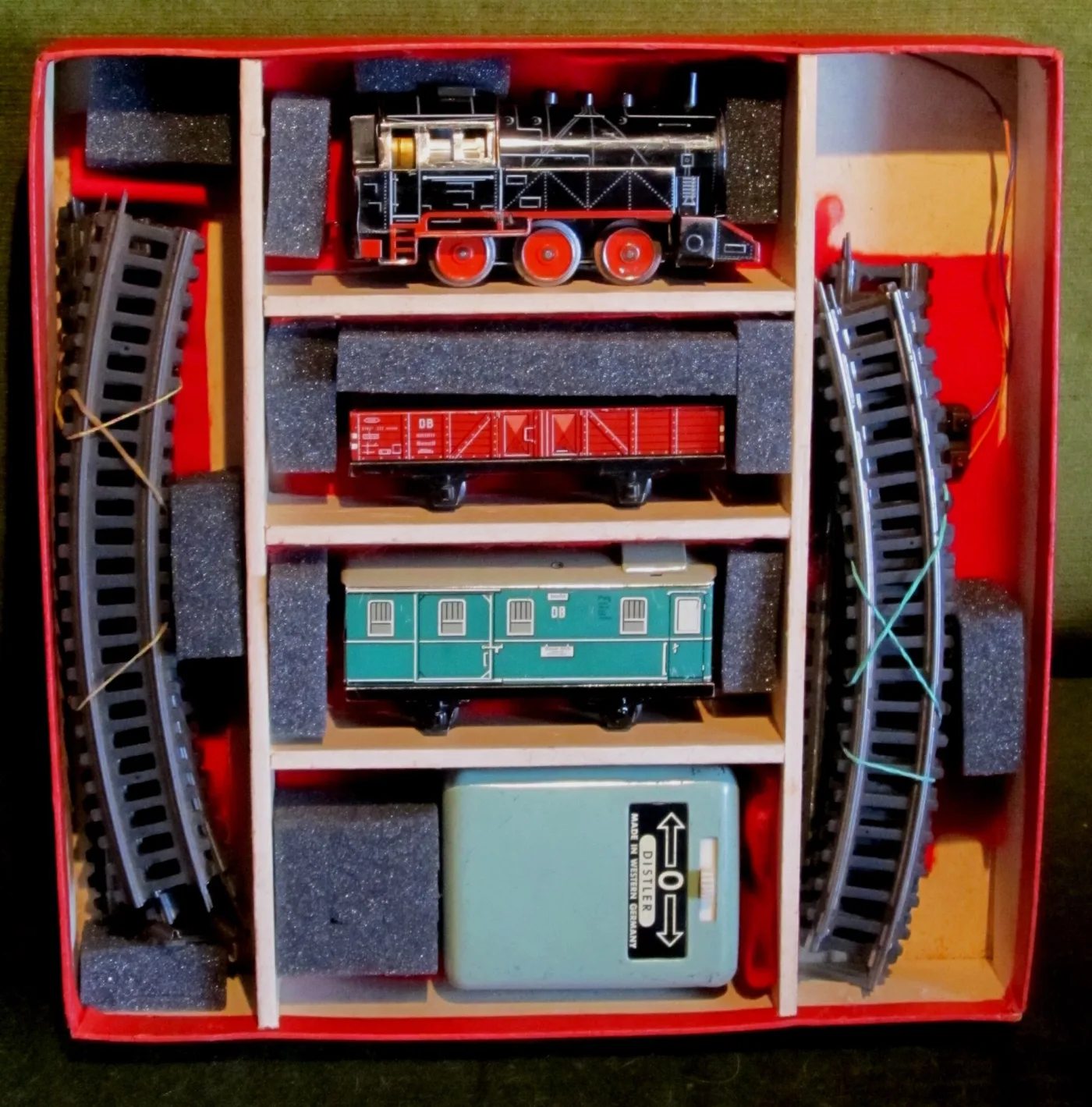 Open train set box with each item held in its own compartment of a slatted card and foam insert