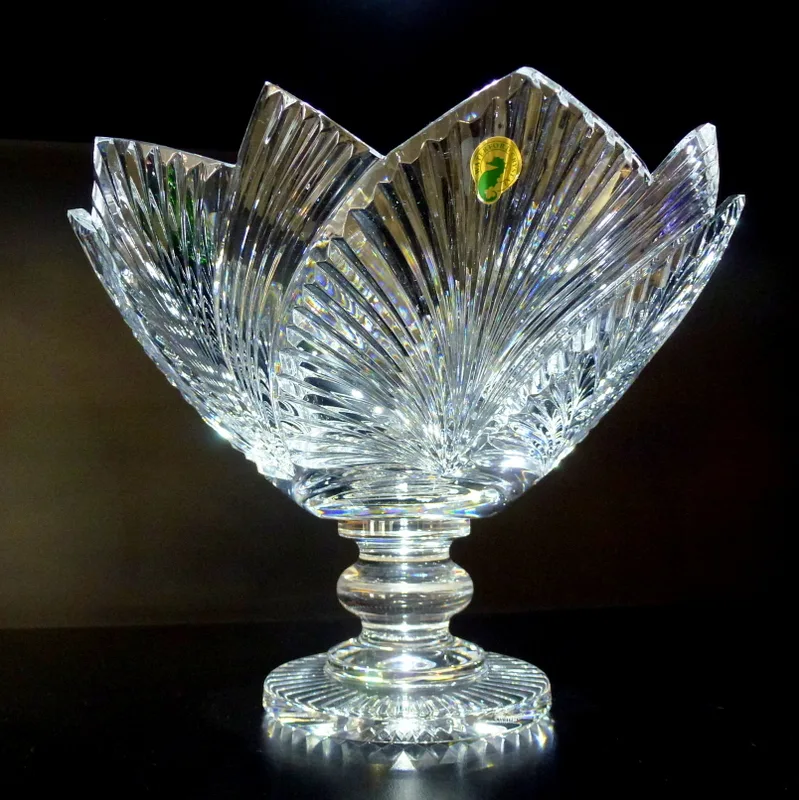 Flaring cut-crystal bowl on a knopped stem and star-cut foot, with a small green oval foil label stuck to one petal