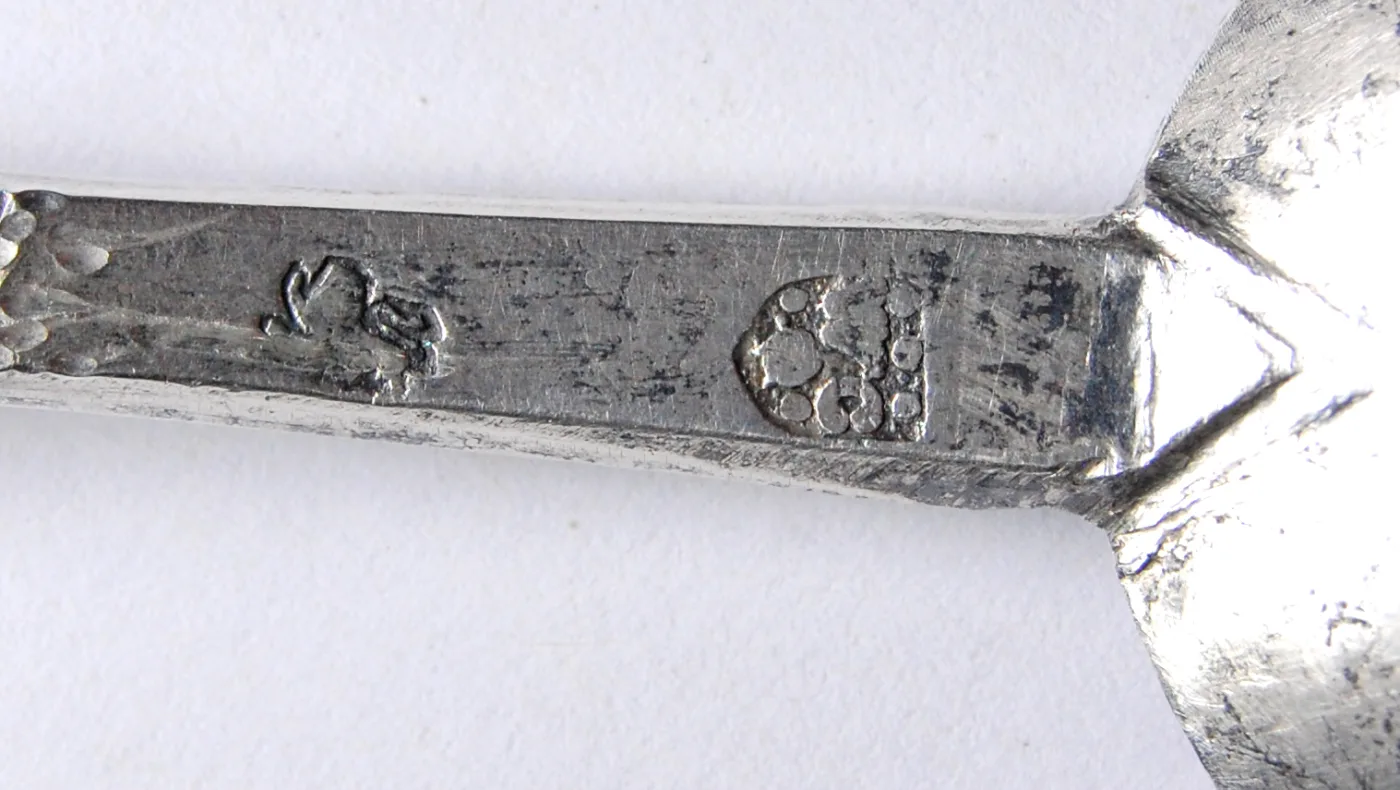 Close-up of a struck maker's mark and a second punch on the stem of an excavated silver spoon