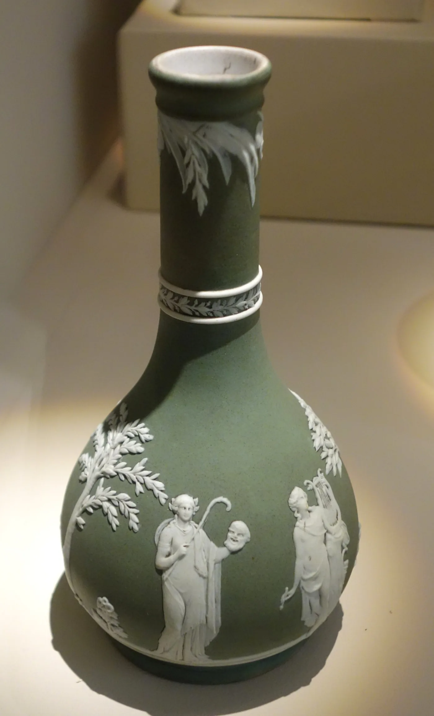 Sage green Wedgwood jasper bottle vase with white classical figures and a white banded collar on the neck